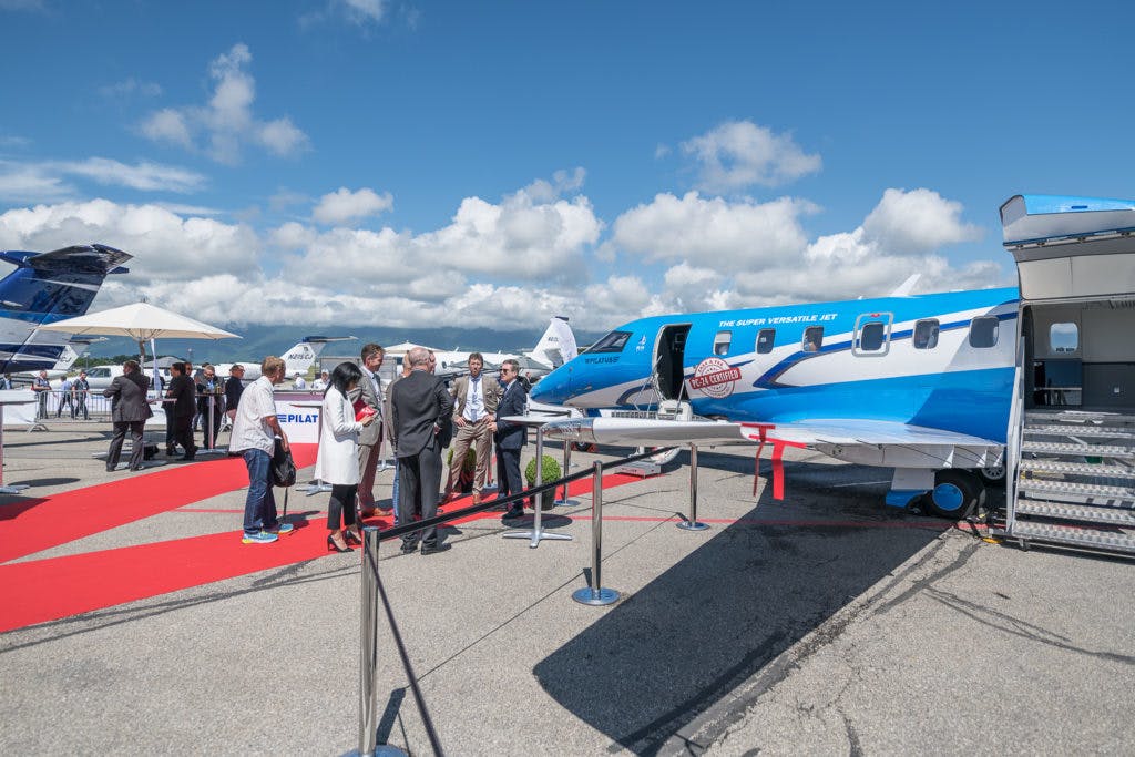 Exhibitors and attendees explore the static display at Geneva International Airport.