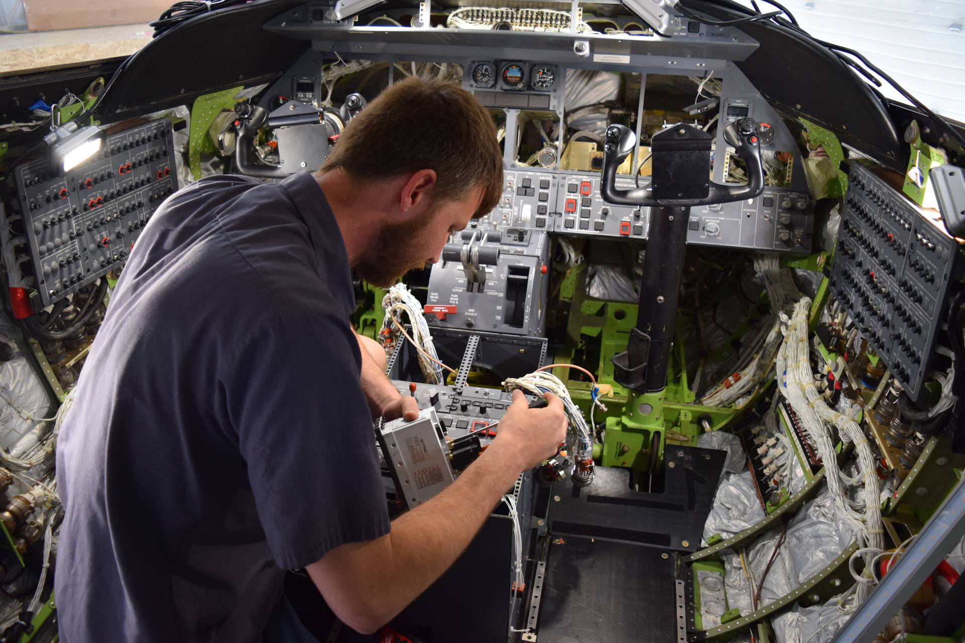 Fargo Jet Center technician Cole Anderson installs a system controller for Skytrac Satcom system retrofit in conjunction with WAAS & ADS-B upgrades in a Lear 45.