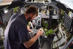 Fargo Jet Center technician Cole Anderson installs a system controller for Skytrac Satcom system retrofit in conjunction with WAAS &amp; ADS-B upgrades in a Lear 45.