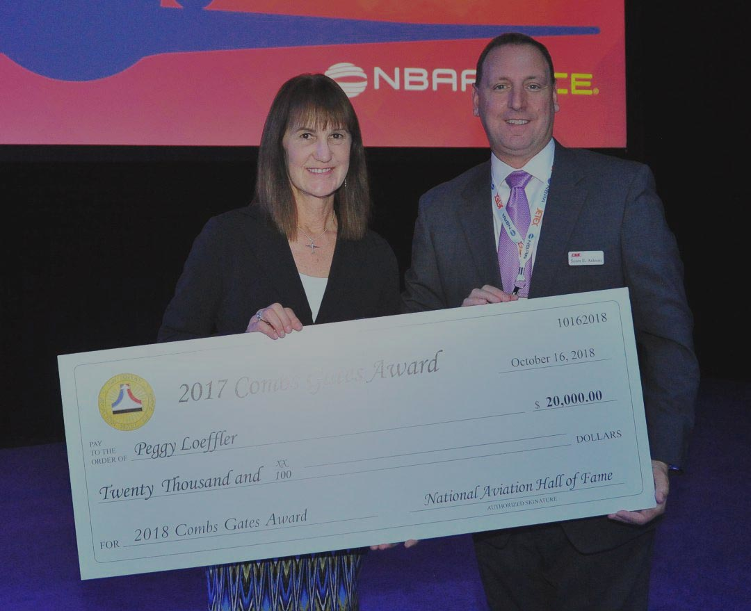 Peggy Loffler and NEAM Board President Scott Ashton receive the Combs Gate Award from the National Aviation Hall of Fame.