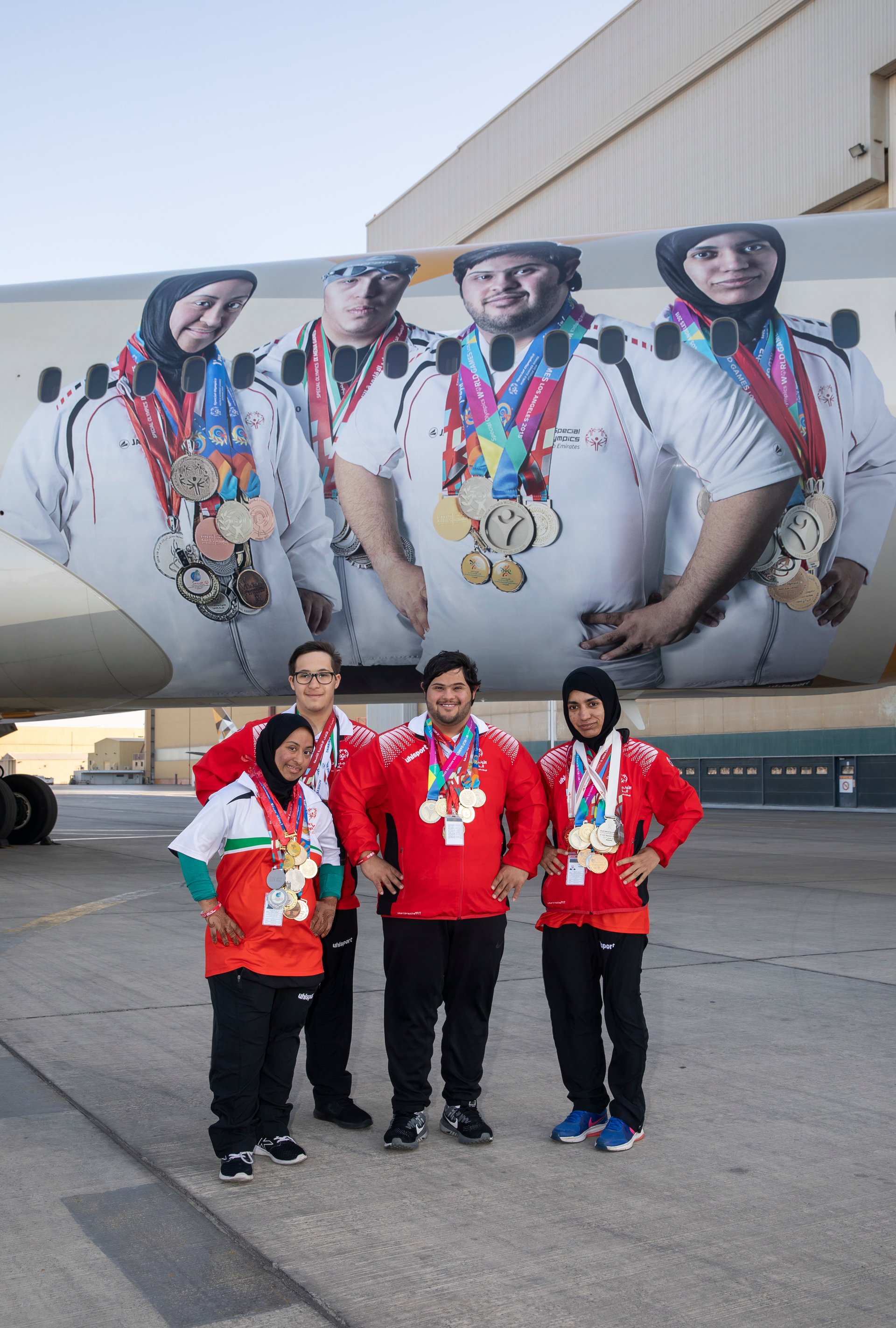 Special Olympics athletes infront of the branded Boeing 787-9.