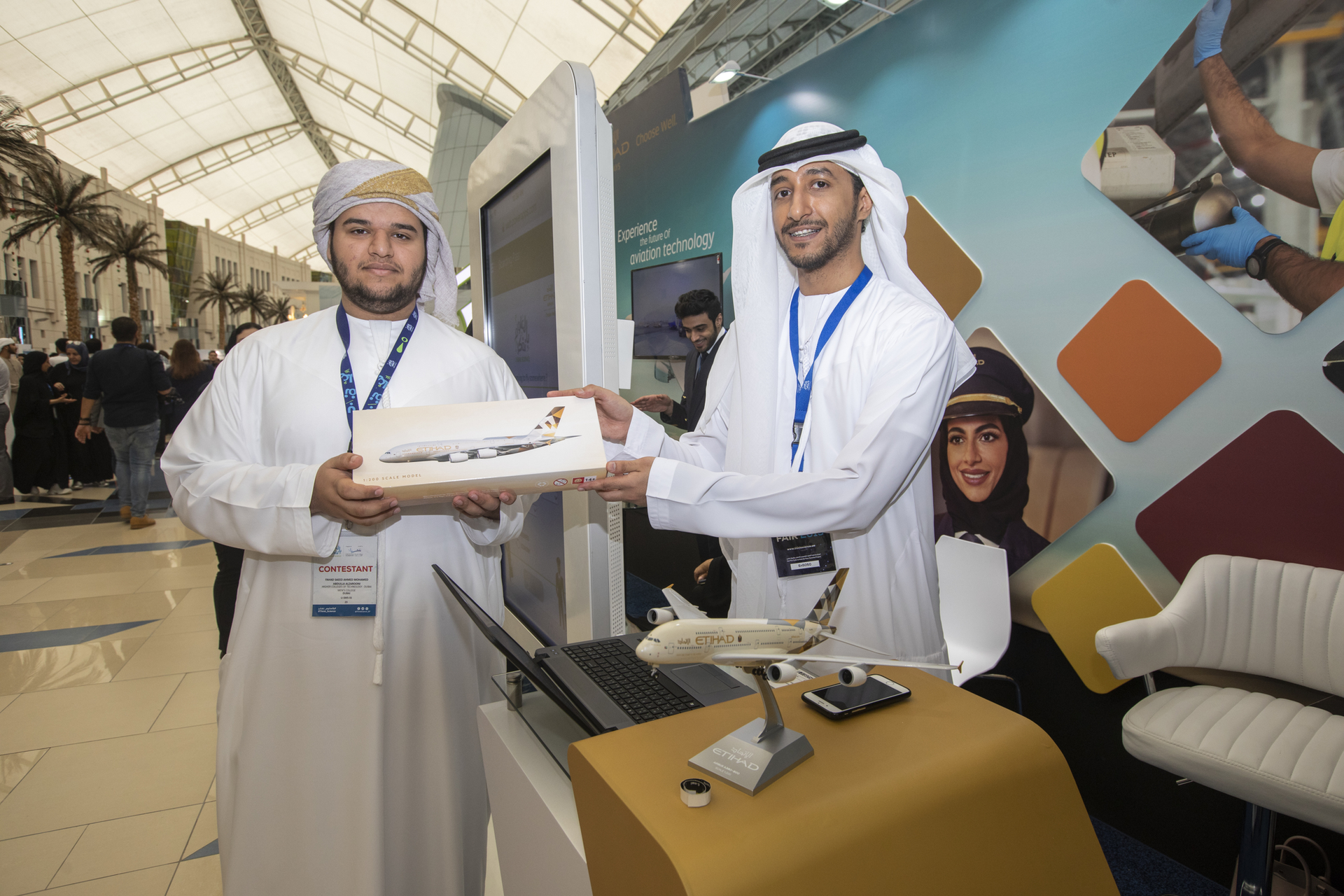 (From left): A young innovator at Think Science Fair, with Abdul Rahman Ahmad Alawi, IT Project Officer, Etihad Airways, at Etihad Aviation Group's stand.