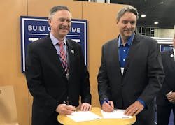 David Davenport, Co-CEO and President, Commercial of FlightSafety International, and Leo Morrissette, Executive Vice President of Air Methods signing the agreement.
