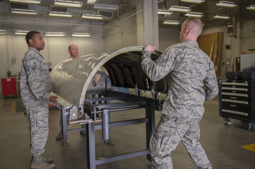 U.S. Air Force sheet metal technicians with the 116th and 461st Air Control Wing(s) aircraft structural maintenance sections secure a cowling on the newly-created cowling fixture table April 3, 2019, at Robins AFB, Ga. Eight Airmen from Team JSTARS recently designed an innovative tool estimated to save the Air Force nearly $500k a year in cowling repairs for the aircraft.