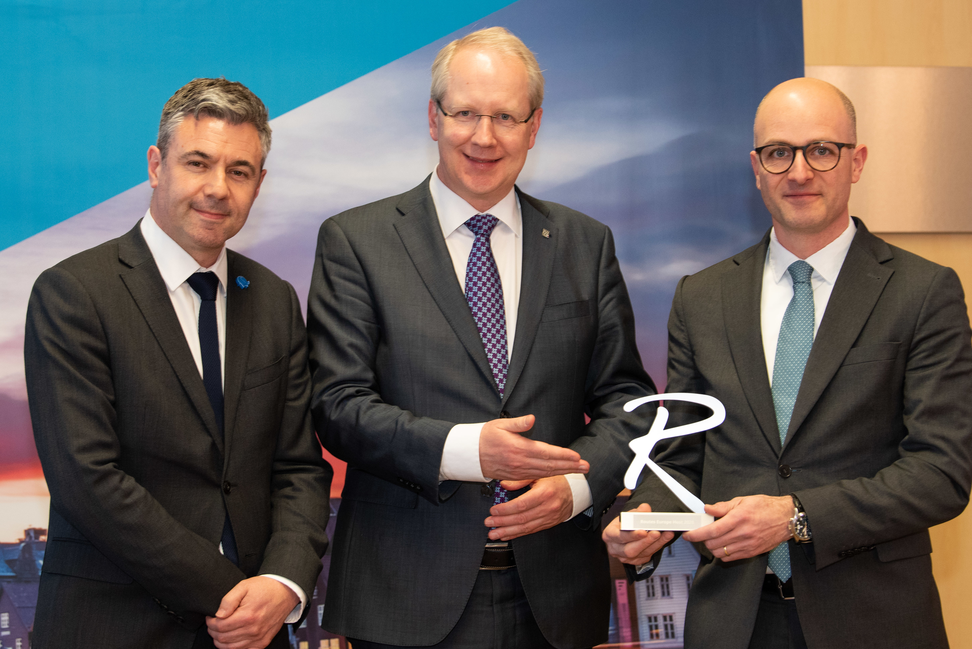 Stefan Schostok, Mayor and CEO of the City of Hannover (center), passes the event trophy to Jasper Spruit (right), vice president of traffic development, Avinor, accompanied by Steven Small, brand director, Routes (left)