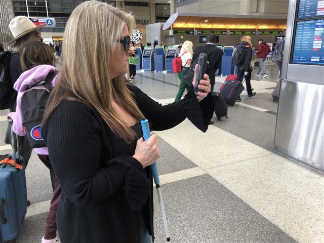 An Aira guide connects to Maria Johnson's smartphone and provides real-time descriptions of the Tom Bradley International Terminal's Departures level.