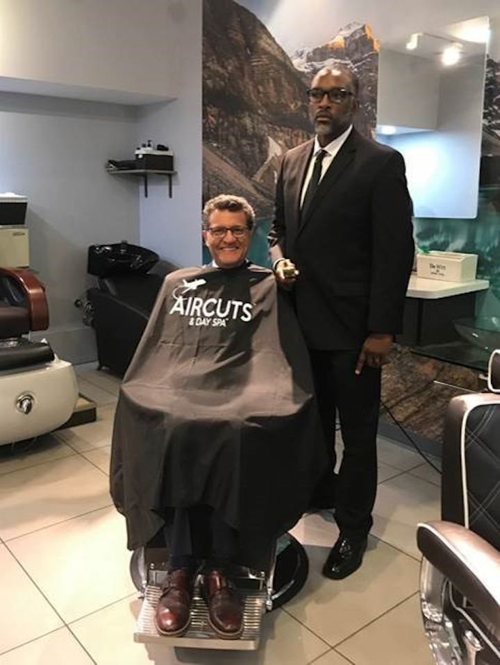 Fraport USA CEO Ben Zandi takes a seat in the barber’s chair for a ceremonial “first haircut” at the new Aircuts & Day Spa at Cleveland Hopkins International Airport.