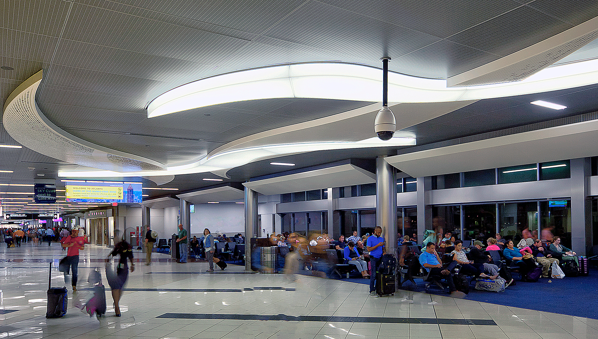 The two-year, $112.7 million contract to recast and brighten up the hold rooms included removing existing storefront systems and portions of exterior metal panels to install floor-to-ceiling glass, upgrade lighting, replace flat acoustical ceilings with sloped metal ceiling panels, install new carpet and repaint the hold rooms.