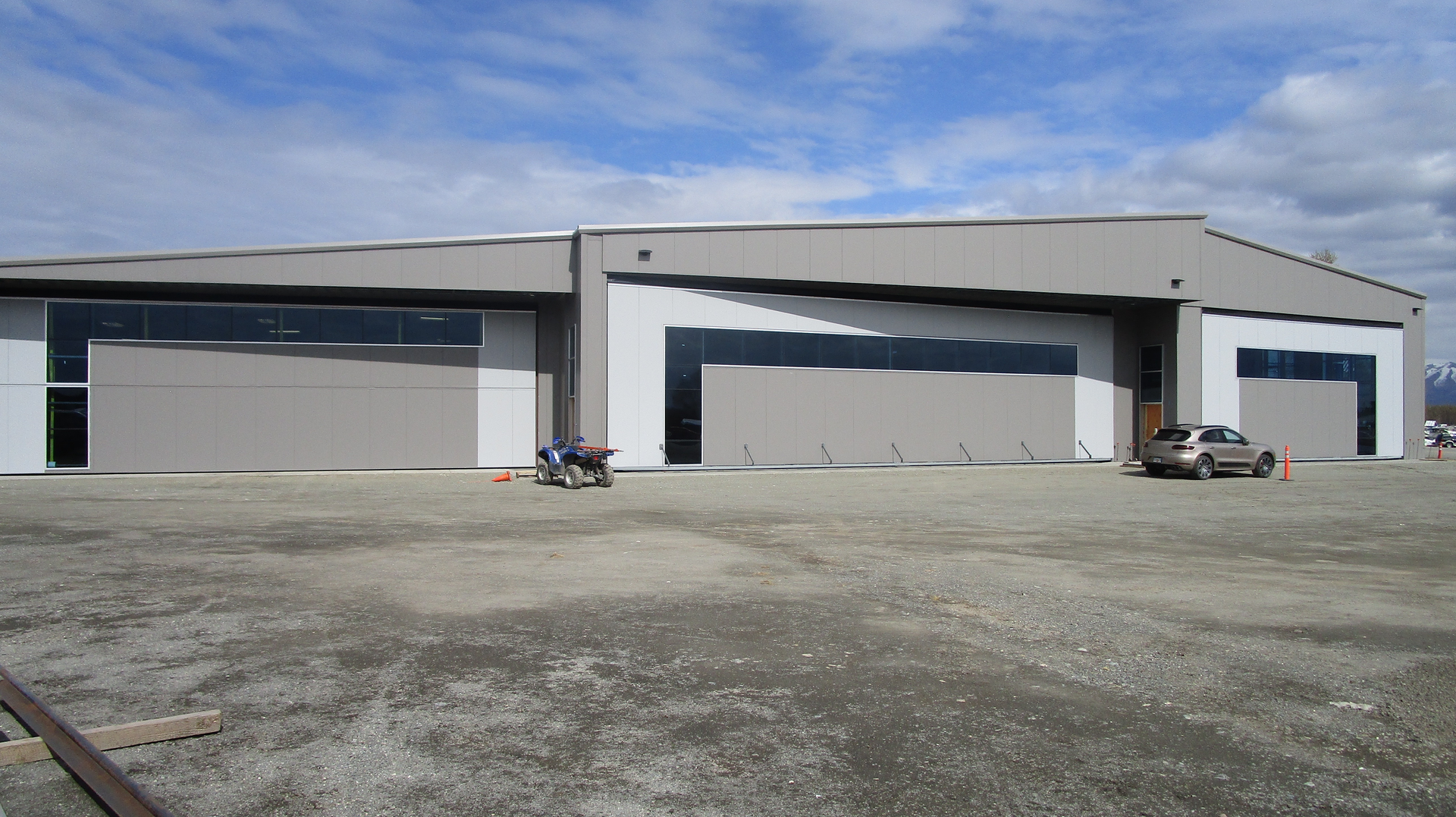 This Lake Hood Anchorage, Alaska hangar has two bifold doors and a hydraulic door at its center. The decorative window design really sets it off from other hangars.