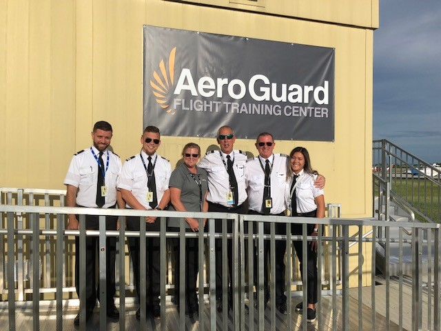 The Florida team and their students celebrate the opening of AeroGuard's newest campus. Pictured from left to right are: Nik Kaszuba, Max Silva, Debbie Ederer, Mark Pysher, Pierre Cieciorko, Sydney Zhang