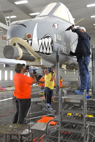Anthony Montanez, Dennis Reeves and Brady Ringel, 576th Aircraft Maintenance Squadron technicians, prepare the first production A-10 Thunderbolt II for paint removal using a new robotic media blast technology Dec. 4, 2019, at Hill Air Force Base, Utah. The corrosion control technicians seal up the seams and holes in the outer-surface skin to prevent the blast media from entering the aircraft.