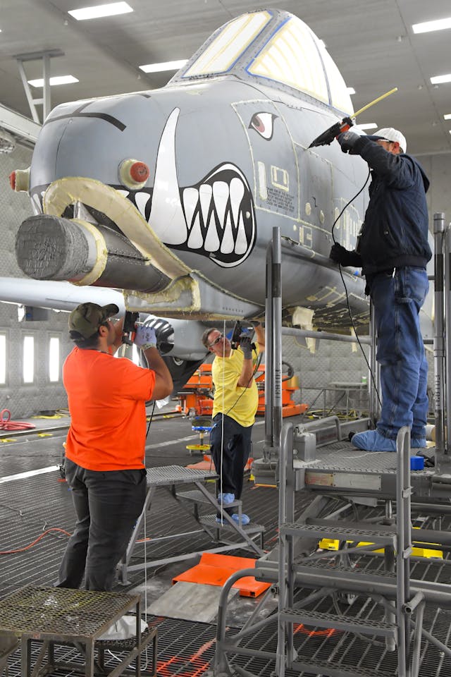 Anthony Montanez, Dennis Reeves and Brady Ringel, 576th Aircraft Maintenance Squadron technicians, prepare the first production A-10 Thunderbolt II for paint removal using a new robotic media blast technology Dec. 4, 2019, at Hill Air Force Base, Utah. The corrosion control technicians seal up the seams and holes in the outer-surface skin to prevent the blast media from entering the aircraft.