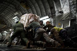 Members of the 99th Logistics Readiness Squadron and the Royal Australian Air Force push a pallet of fire suppressant up the ramp of an Australian C-17 Globemaster III, Jan. 16, 2020 at Nellis Air Force Base, Nev. Airmen from the United States and Australian Air Forces worked together to load the aircraft with the cargo to be delivered to Australia for aid in wildfire relief.