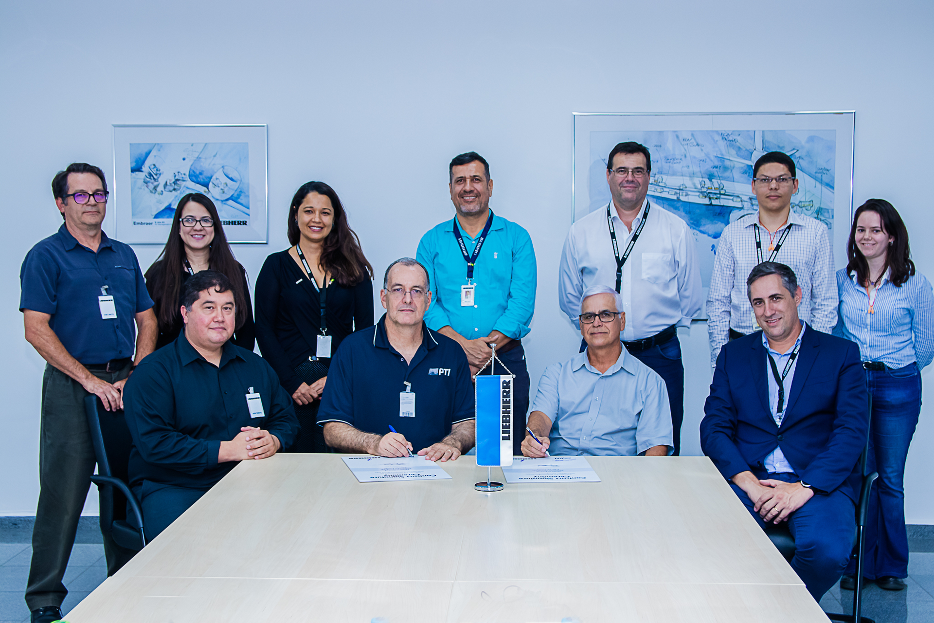 At the table from left to right: Ray Lopez, Quality Director (PTI), Eduardo Girotto, Sr. Director, Manufacturing (PTI), Tadeu Coelho, Financial and Administrative Director (Liebherr Aerospace Brasil) and Rog&eacute;rio Gimenez, Managing Director Operations (Liebherr Aerospace Brasil) were joined by members of the Liebherr Aerospace Brasil team during the contract signature ceremony.