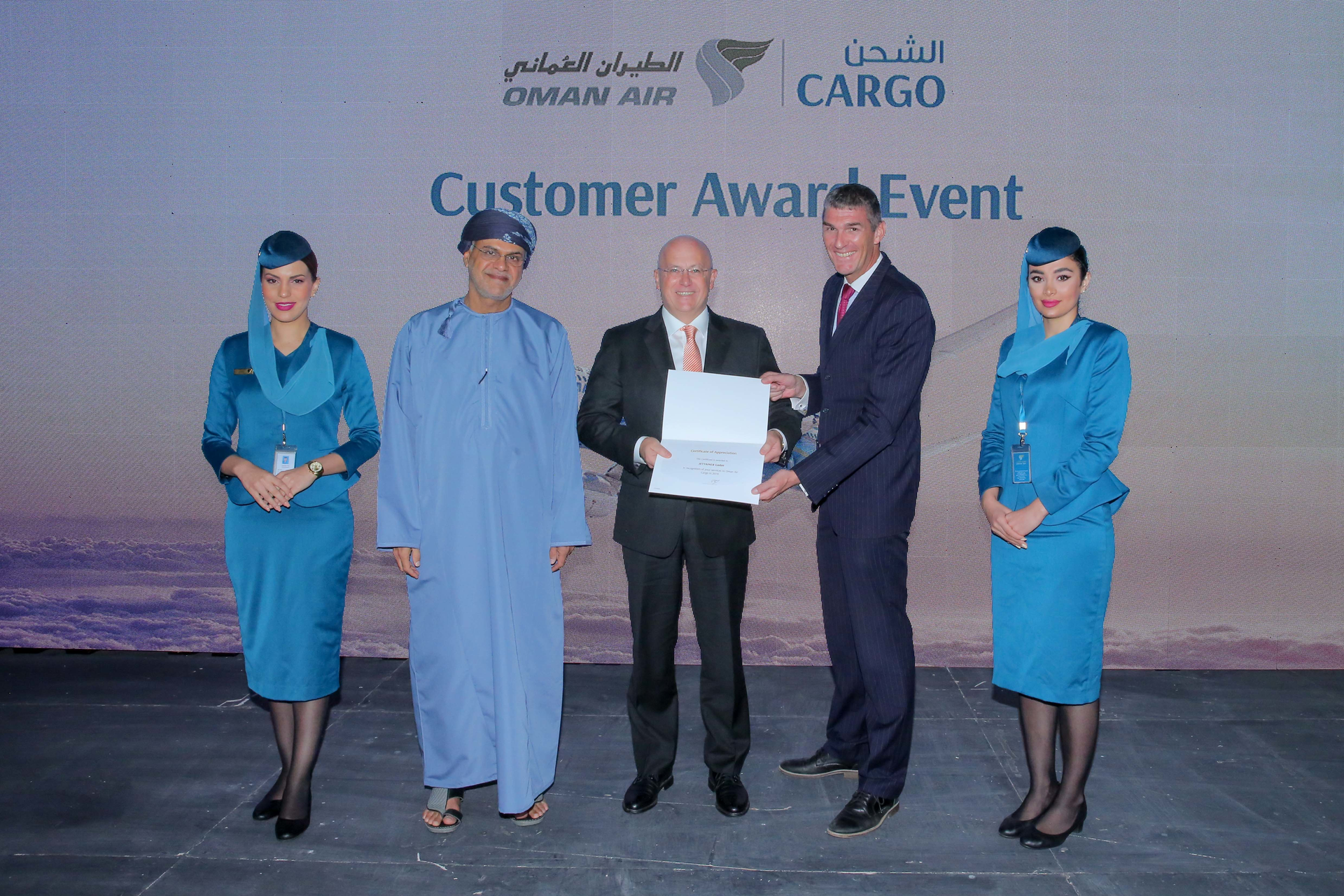 Mohammed Al Musafir, SVP Commercial Cargo of Oman Air (left), and Paul Robert Starrs, Chief Commercial Officer of Oman Air (right), present the award to Thomas Sonntag, CEO of Jettainer GmbH.