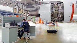 Aircraft Maintenance Technician At A Workstation In A Maintenance Hangar
