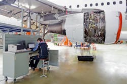 Aircraft Maintenance Technician At A Workstation In A Maintenance Hangar