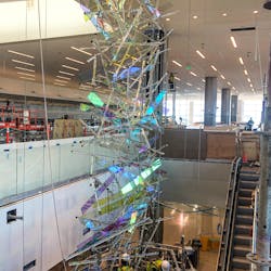 Comprised of roughly 300 dichroic glass panels, and 220 hand drawn glass and Pyrex rods, this 65-foot-tall suspended sculpture cascades down the escalator well at the entrance to the new main termina