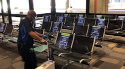 A TPA employee uses an electrostatic sprayer to disinfect the airport&apos;s seating.