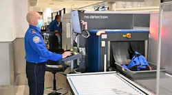 TSA officer inspecting items using new CT technology.