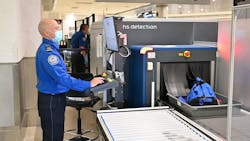 TSA officer inspecting items using new CT technology.