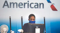 An American Airlines employee waits to help a passenger check luggage in Terminal A at DFW International Airport.