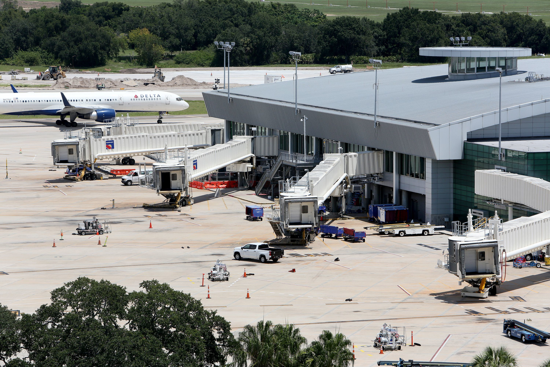 Terminals for Southwest Airlines remain mostly empty as a Delta Airlines plane taxis past the airside terminal at Tampa International Airport on Aug. 14.
