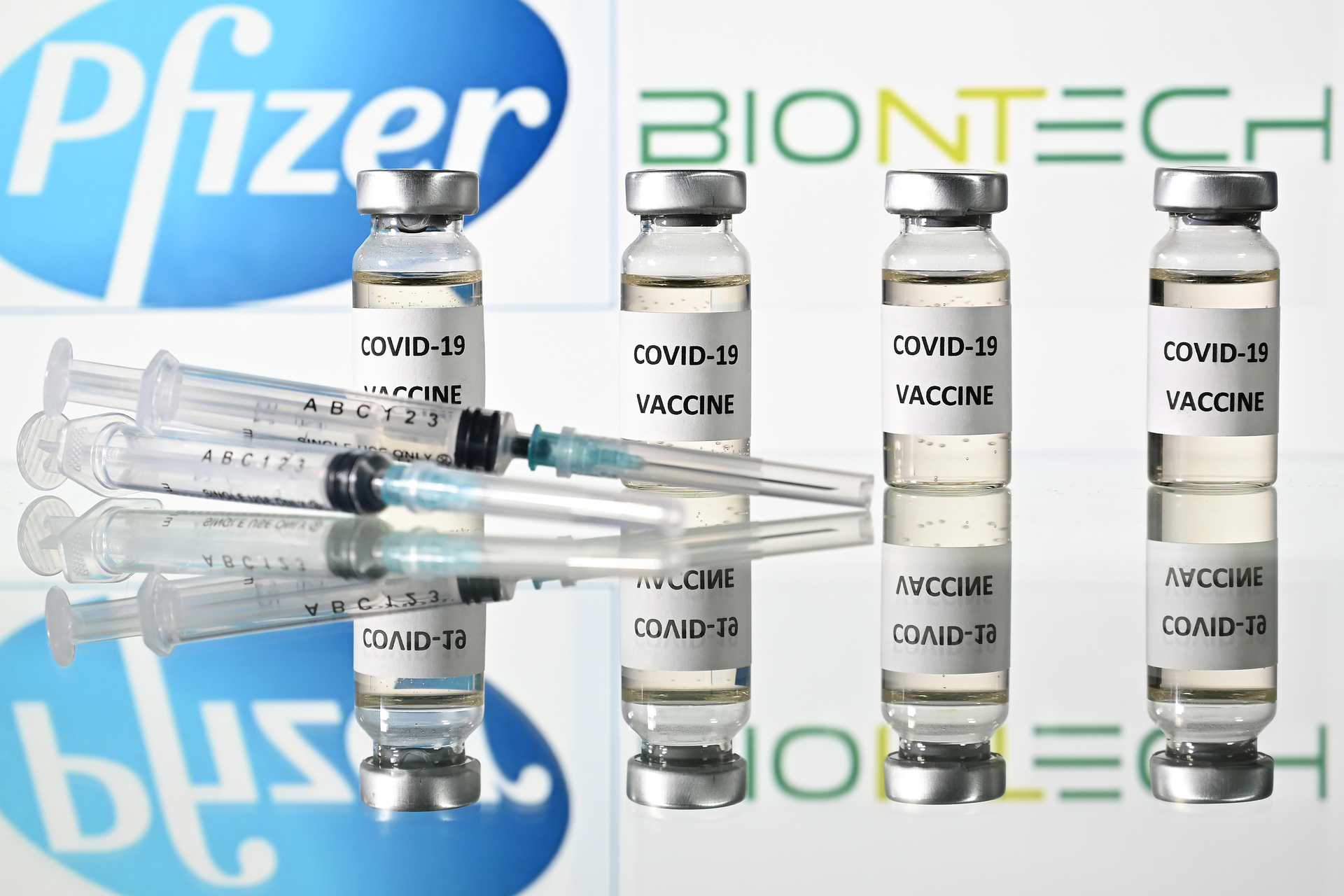 An illustration picture shows vials with Covid-19 Vaccine stickers attached and syringes with the logo of US pharmaceutical company Pfizer and German partner BioNTech, on November 17, 2020.