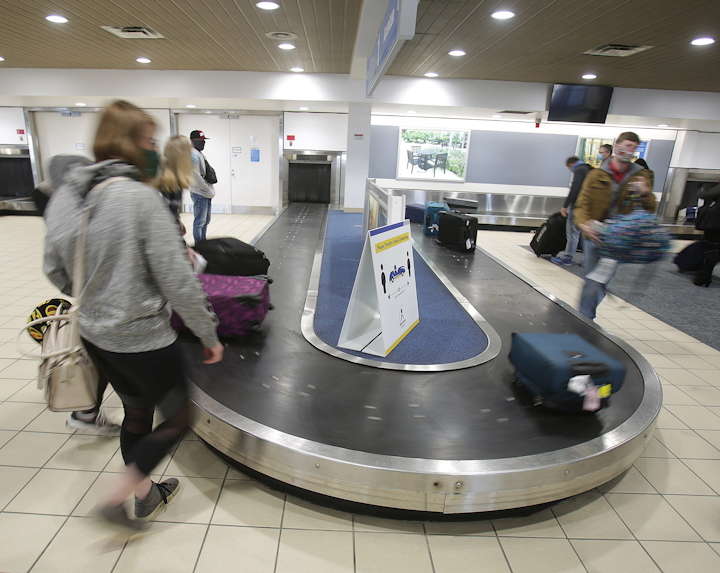 Passengers grab their luggage at Akron - Canton Airport after arriving from Charlotte, North Carolina, in late December.