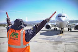 An ATS worker marshalling a plane.