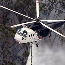 A Sikorsky S 61 Helicopter Performs A Water Drop During An Aerial Firefighting Mission