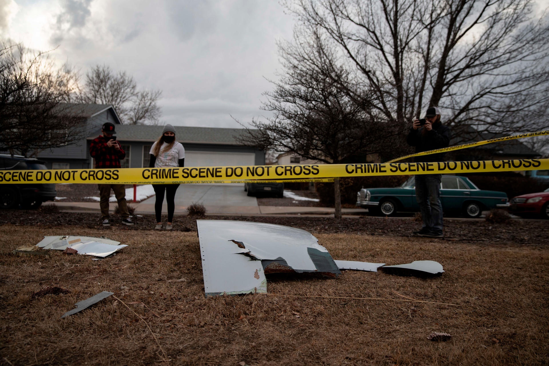 Residents take pictures of debris fallen from a United Airlines airplane's engine in the neighborhood of Broomfield, outside Denver, Colorado, on February 20, 2021 - A United Airlines flight suffered a fiery engine failure on February 20, shortly after taking off from Denver on its way to Hawaii, dropping massive debris on a residential area before a safe emergency landing, officials said.