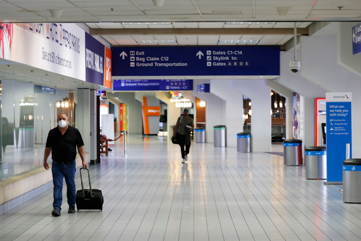 People make their way through terminal C at DFW International Airport on Wednesday, April 8, 2020.