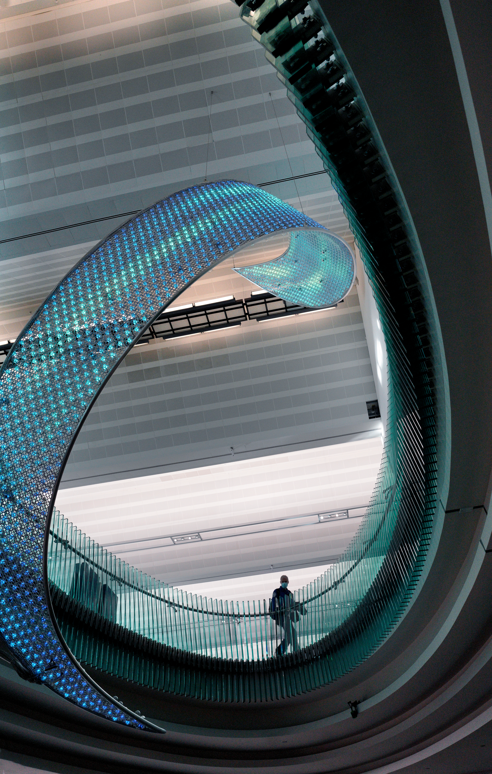For the past two years, NYC-based artist Jen Lewin has been working on a major interactive public artwork, entitled 'Aurora,' at MSP Airport. The Aurora consists of 23,000 aluminum rings that form a 29-foot high interactive hanging sculpture that spans between the baggage claim level through an oval opening to the ticket area. The artwork holds 2,667 hand blown glass bulbs with LEDs inside. Below the Aurora, imbedded in the floor are reflective cluster of lake forms that when walked on trigger interactive colors beneath their feet and activate whips of color up into the Aurora.