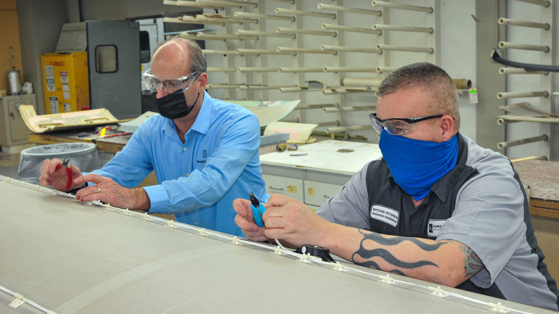 Bongiovi Rep Rob Hamelink and Duncan Aviation Avionics Modifications Specialist Ritchie Peterson work on installing transducers for the Bongiovi Aviation audio system.