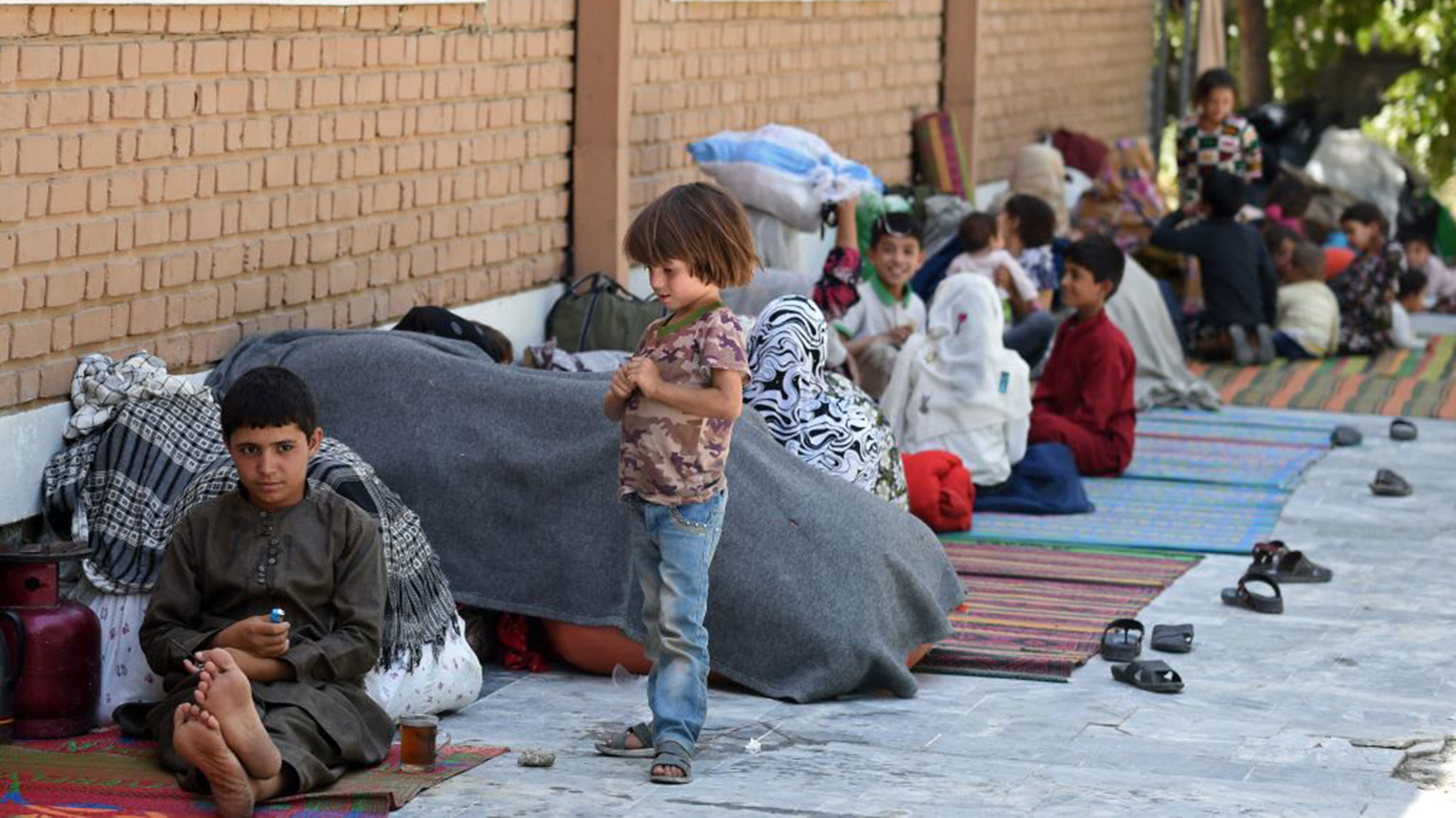 Internally displaced Afghan families, who fled from the northern province due to battle between Taliban and Afghan security forces, sit in the courtyard of the Wazir Akbar Khan mosque in Kabul on Aug. 13, 2021.