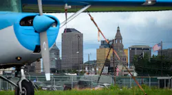 With the Hartford skyline in the background, a secured plane rests on the tarmac at Brainard airport.