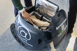 Port of Seattle Commissioner Commissioner Sam Cho places food inside Gita, an Order SEA robot, during a demonstration in the north satellite at Seattle-Tacoma International airport Thursday, September 9, 2021.