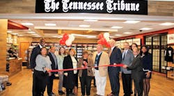 Nov. 19 guests celebrate the grand opening of The Tennessee Tribune store at Nashville International Airport with Tribune founder and publisher/CEO Rosetta Miller-Perry in a special tribute to her 30-year legacy. The state&rsquo;s largest minority newspaper marks three decades serving the African-American community. Pictured left to right are Davita Taylor, vice president, Procurement &amp; Business Diversity, Metropolitan Nashville Airport Authority (MNAA); Forrest E. Harris Sr., president, American Baptist College; Michael Hooks; Janet Hooks; Wanda Miller-Benson (Rosetta&rsquo;s daughter); Rosetta Miller-Perry (center, holding scissors); Bill Freeman, chairman, MNAA Board of Commissioners; Doug Kreulen, president and CEO, MNAA; Matt Jennings, vice president, Fraport Tennessee; Jennifer Winchester, ACDBE partner, TRNA Nashville; Steve Benson; and Juney June, The Tennessee Tribune.