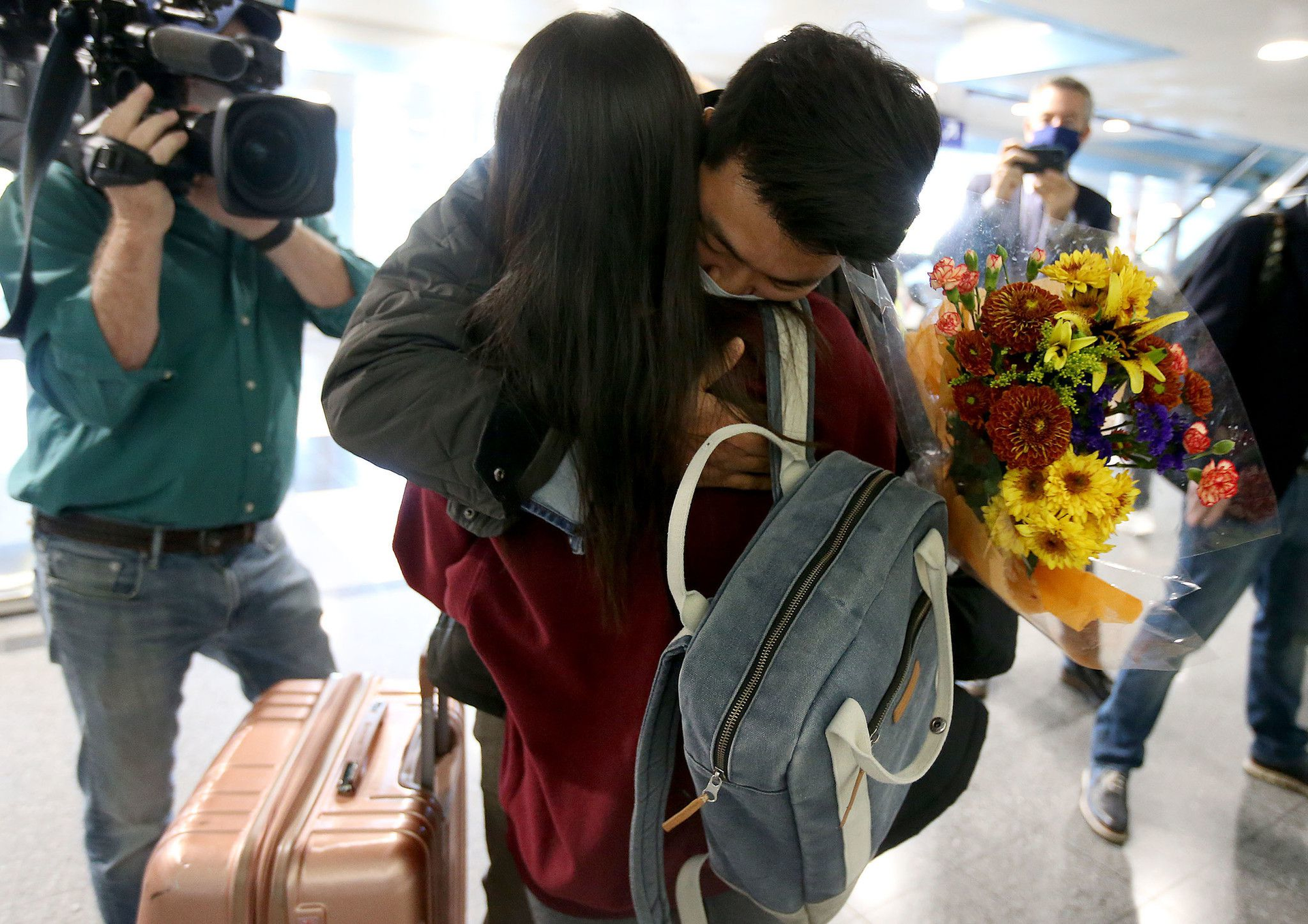 After arriving at O'Hare International Airport from Germany, Yerin Hong is greeted by her boyfriend, Soon Kim, with flowers on Nov. 8, 2021. The U.S. lifted the pandemic travel ban for vaccinated international travelers.