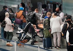 Holiday travelers &mdash; human and one canine &mdash;waited in line at the Delta ticketing counter of Terminal 1 at the Minneapolis-St. Paul International Airport on Monday.
