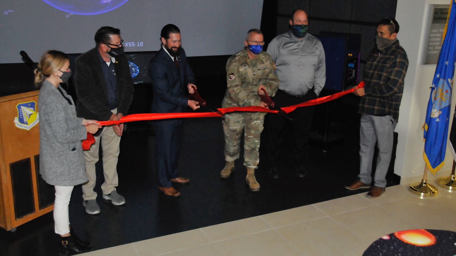 Col. Eric Felt, director of the Air Force Research Laboratory Space Vehicles Directorate and Dr. Darren Raspa, AFRL Phillips Research Site historian, cut the ribbon to open the directorate&rsquo;s Legacy Portal Mission Control exhibit, at a ceremony held Nov. 15 at Kirtland AFB, N.M. Supporting them left to right: Gina Gutierrez, project manager; Bradley Rieck, senior facility engineer; Dan Von Tom, chief of the Corporate Information Office; and Victor Mace, project coordinator.