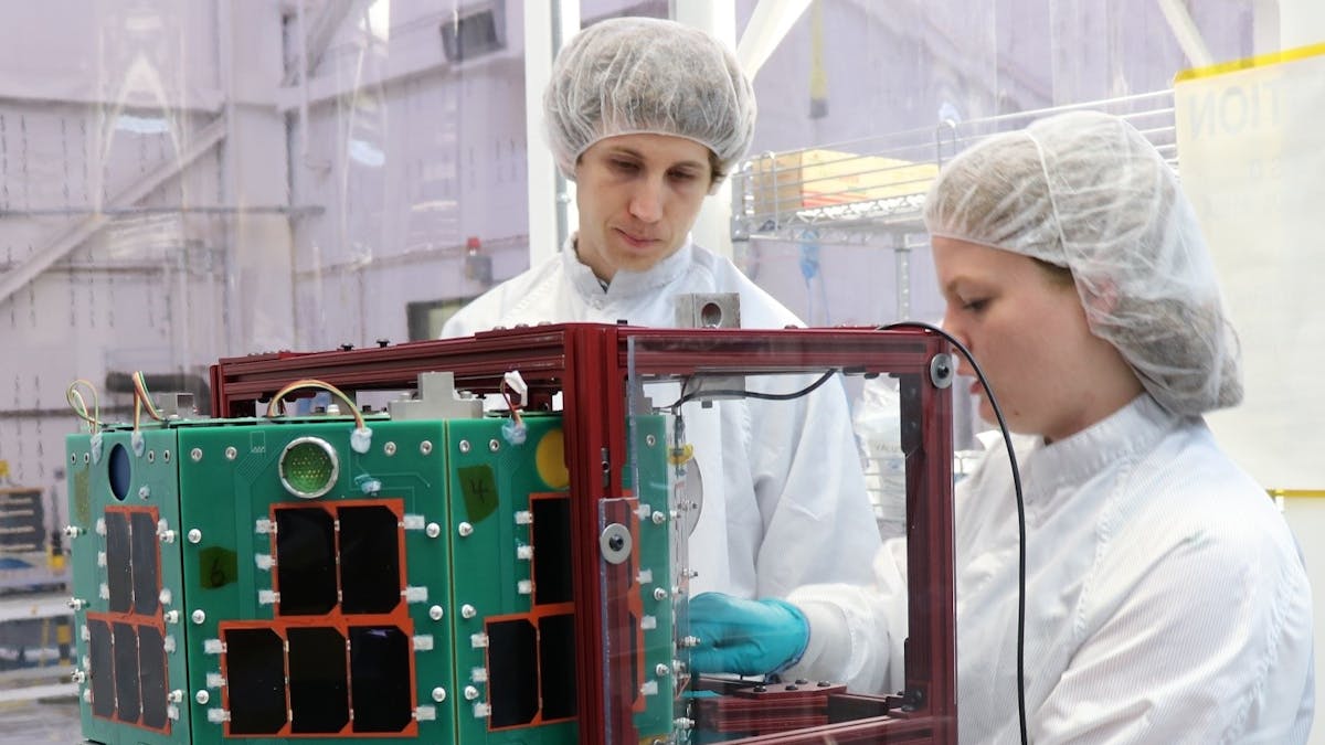 Two University Nanosatellite Program students assemble the Oculus-ASR satellite.