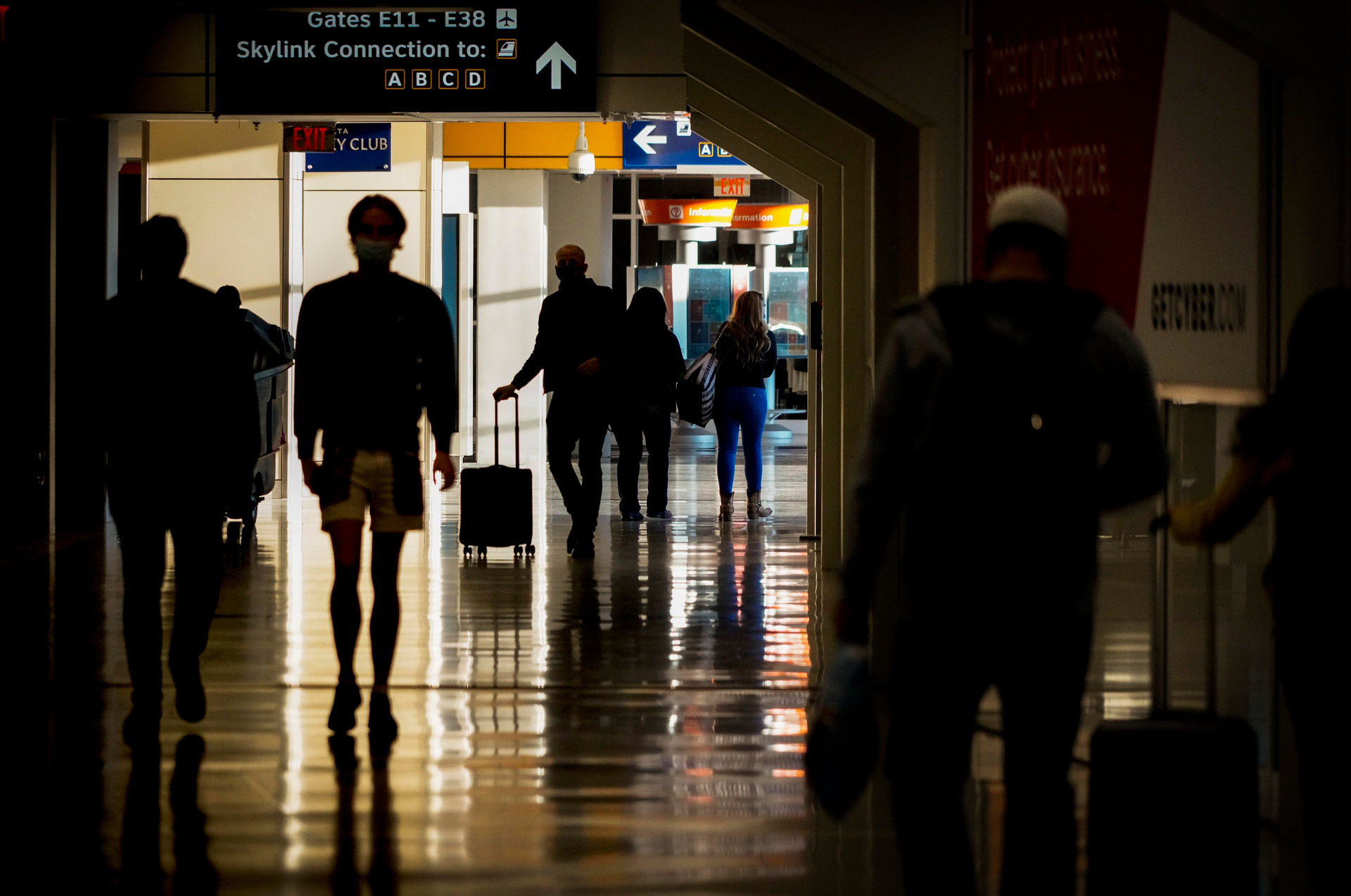 Passengers walk between gates of Terminal E on Saturday, Dec. 11, 2021, at DFW Airport.