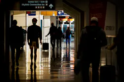 Passengers walk between gates of Terminal E on Saturday, Dec. 11, 2021, at DFW Airport.