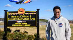 Izaiah Brown, a University of Maryland Eastern Shore aviation science student and aspiring pilot, stands for a portrait Nov. 26, 2021, at the Thomas A. Dixon Jr. Aircraft Observation Center as a Southwest Airlines plane flies behind him.