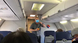 A Southwest Airlines flight attendant, wearing one mask, demonstrates the use of an oxygen mask at the outset of flight from Burbank, California, to Las Vegas in June 2021.