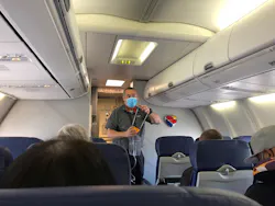 A Southwest Airlines flight attendant, wearing one mask, demonstrates the use of an oxygen mask at the outset of flight from Burbank, California, to Las Vegas in June 2021.