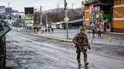 A Ukrainian soldier walks past a building that was destroyed in the midst of battle with the Russians, on the outskirts of Irpin, Ukraine, Tuesday, March 1, 2022.