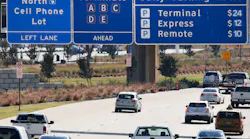 Road signs on Highway 114 inform drivers where the cellphone lot is located before the northbound entrance to DFW International Airport on Nov. 10, 2017. This will allow people to park and wait near the entrance of the airport without incurring parking fees.